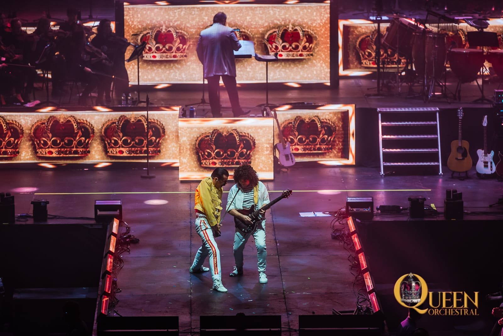 Shot of our Freddie and Brian of QUEEN Orchestral at the 3Arena, stage bathed in gold light, the Queen crown and the crowd were on their feet.